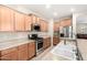 This is a lovely kitchen with a large sink, stainless steel appliances, and wood cabinets at 163 W Dragon Tree Ave, Queen Creek, AZ 85140