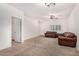 Living area featuring brown couches and view into hallway at 163 W Dragon Tree Ave, Queen Creek, AZ 85140