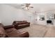 Living room with brown leather couches and ceiling fan at 163 W Dragon Tree Ave, Queen Creek, AZ 85140