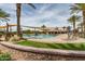 Resort style pool featuring covered seating areas, mature palm trees, lounge seating, and well maintained landscaping at 163 W Dragon Tree Ave, Queen Creek, AZ 85140