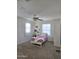 Bright bedroom with ceiling fan, double windows, and white bed frame at 16425 W Latham St, Goodyear, AZ 85338