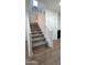 Carpeted staircase with white railings and access to upper level at 16425 W Latham St, Goodyear, AZ 85338