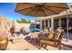 Relaxing patio area with comfortable seating and umbrella near the pool at 17164 S 174Th Dr, Goodyear, AZ 85338