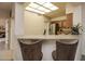 Kitchen breakfast bar with two brown suede barstools at 18619 N 136Th Dr, Sun City West, AZ 85375