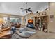 Living room with a large TV, leather couches, and a ceiling fan at 1902 E Bruce Ave, Gilbert, AZ 85234