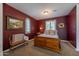 Bedroom with wooden bed frame and red walls at 19334 W Pasadena Ave, Litchfield Park, AZ 85340