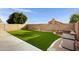 Artificial turf backyard with fire pit and sitting area at 2023 E Glenhaven Dr, Phoenix, AZ 85048