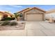 Tan house with tile roof, two-car garage, and desert landscaping at 2023 E Glenhaven Dr, Phoenix, AZ 85048