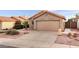 Tan house with a two-car garage, landscaping, and a paved driveway at 2023 E Glenhaven Dr, Phoenix, AZ 85048