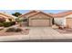 Tan house with a two-car garage, landscaping, and a paved driveway at 2023 E Glenhaven Dr, Phoenix, AZ 85048