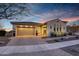 Charming single-story home featuring a paver driveway, three-car garage, and desert landscaping at 20641 W Medlock Dr, Buckeye, AZ 85396