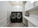 Well-lit laundry room with a front-loading washer and dryer and white cabinets for plenty of storage at 20641 W Medlock Dr, Buckeye, AZ 85396