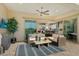 A covered patio featuring wicker furniture, an outdoor ceiling fan, and sliding glass doors to the kitchen at 20641 W Medlock Dr, Buckeye, AZ 85396