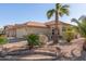 House with a landscaped yard, palm trees and a two-car garage at 23205 W Arrow Dr, Buckeye, AZ 85326