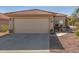 Tan house with a two-car garage and small front yard at 23205 W Arrow Dr, Buckeye, AZ 85326