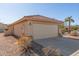 Tan house with a two-car garage and a small front yard at 23205 W Arrow Dr, Buckeye, AZ 85326