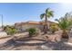 House with a landscaped yard, palm trees and a two-car garage at 23205 W Arrow Dr, Buckeye, AZ 85326