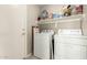 Laundry room with washer, dryer, and overhead shelving at 23205 W Arrow Dr, Buckeye, AZ 85326