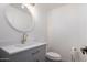 Modern bathroom with gray vanity, gold fixtures, and a white toilet at 2614 E Mountain View Rd, Phoenix, AZ 85028