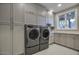 Laundry room with modern washer, dryer, and ample cabinetry at 26905 N 98Th Way, Scottsdale, AZ 85262