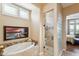 Spa-like bathroom featuring a soaking tub, a walk-in shower, and glass block accents at 29432 N 128Th Ln, Peoria, AZ 85383