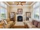 Cozy living room with a fireplace, two sofas, and large windows at 29432 N 128Th Ln, Peoria, AZ 85383