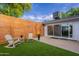 Cozy backyard with artificial turf, wood fence, patio, and charming Adirondack chairs at 3002 E Mitchell Dr, Phoenix, AZ 85016