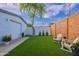 Backyard featuring artificial turf, wood fence, and a detached garage at 3002 E Mitchell Dr, Phoenix, AZ 85016
