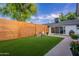 Backyard with artificial turf, a wood fence, patio and lounge furniture at 3002 E Mitchell Dr, Phoenix, AZ 85016