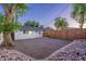 A gravel backyard is enclosed by a modern horizontal wood fence and a charming white house at 3002 E Mitchell Dr, Phoenix, AZ 85016