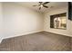 Spacious bedroom with carpeted floor, large window, and ceiling fan at 32807 N 15Th Gln, Phoenix, AZ 85085