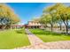 Brick path leads to a community clubhouse with green lawn at 32807 N 15Th Gln, Phoenix, AZ 85085