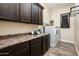 Laundry room with dark wood cabinets and built-in storage at 32807 N 15Th Gln, Phoenix, AZ 85085