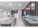 Spacious kitchen featuring granite countertops, dark wood cabinets, and a large island at 35134 N Laredo Dr, San Tan Valley, AZ 85144