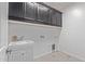 Bright laundry room with white cabinets and built-in sink at 35134 N Laredo Dr, San Tan Valley, AZ 85144