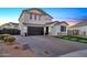 Two-story home with gray brick and a dark garage door, paved driveway, and landscaping at 37762 N Poplar Rd, San Tan Valley, AZ 85140