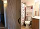 Cozy bathroom with a barn door, shower with floral curtain, built-in shelving and wood vanity at 4043 E Arbor Ave, Mesa, AZ 85206