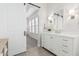 Modern bathroom with white cabinets, a large mirror and a barn door at 42223 N Golden Trl, San Tan Valley, AZ 85140