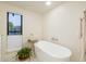 Relaxing bathroom with a freestanding tub and window overlooking the garden at 4432 E Camelback Rd # 120, Phoenix, AZ 85018