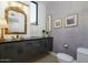 Modern bathroom with dark vanity, decorative mirror, and patterned wall at 4432 E Camelback Rd # 120, Phoenix, AZ 85018