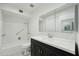 Bathroom featuring a dark vanity cabinet, tile shower and tub, and large mirror at 4800 N 68Th N St # 228, Scottsdale, AZ 85251