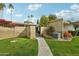 A stone path leads to a gated entrance surrounded by greenery and a brick perimeter wall at 4800 N 68Th N St # 228, Scottsdale, AZ 85251