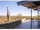 Desert landscape view from expansive patio with mid-century modern furniture at 7724 E Long Rifle Rd, Carefree, AZ 85377