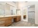 Double vanity bathroom with wood cabinets and a walk-in closet at 9007 E Emerald Dr, Sun Lakes, AZ 85248