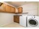 Laundry room with washer, dryer and wood cabinets at 9007 E Emerald Dr, Sun Lakes, AZ 85248