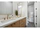 Elegant bathroom with dual sinks, quartz counters, and a tiled shower at 9248 E Desert Village Dr, Scottsdale, AZ 85255