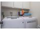 Bright laundry room with washer, dryer, and overhead cabinets at 9614 W Long Hills Dr, Sun City, AZ 85351