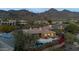 Luxury home with pool and mountain views at dusk at 11127 E Mirasol Cir, Scottsdale, AZ 85255