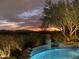 Stunning pool area with cascading waterfall feature and vibrant landscape under a picturesque twilight sky at 11127 E Mirasol Cir, Scottsdale, AZ 85255
