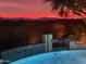 Beautiful pool with tiled accents and flowing waterfall feature set against a vivid sunset backdrop at 11127 E Mirasol Cir, Scottsdale, AZ 85255